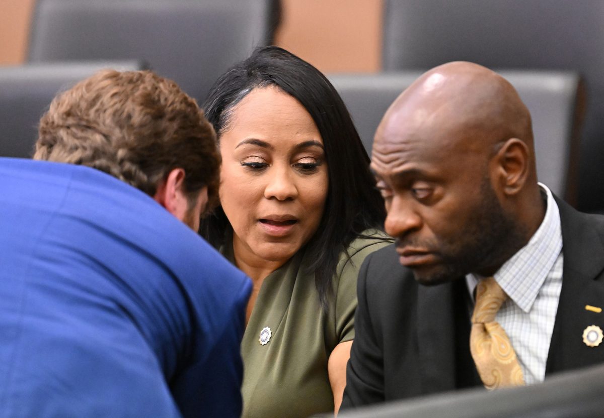 Fulton County District Attorney Fani Willis, center, confers with lead prosecutors, Donald Wakeford, left, and Nathan Wade, during a motion hearing at Fulton County Courthouse in Atlanta on July 1, 2022. (Hyosub Shin/Atlanta Journal-Constitution)